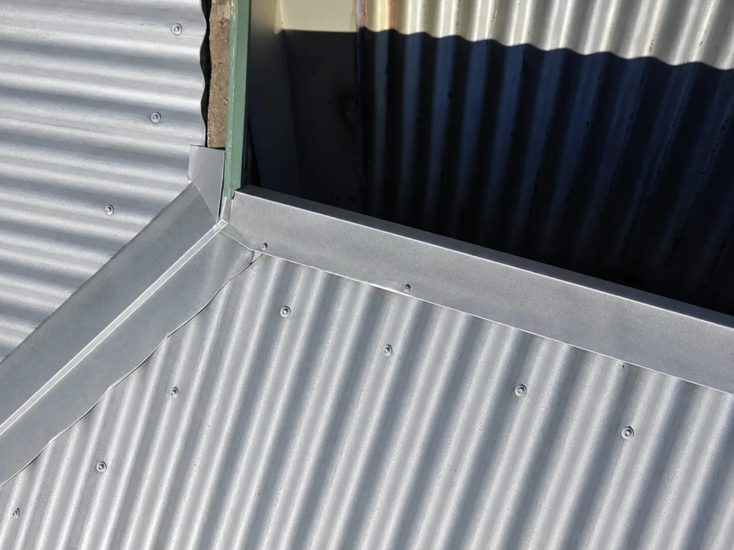 Matching after view of the repaired corrugated metal roof junction