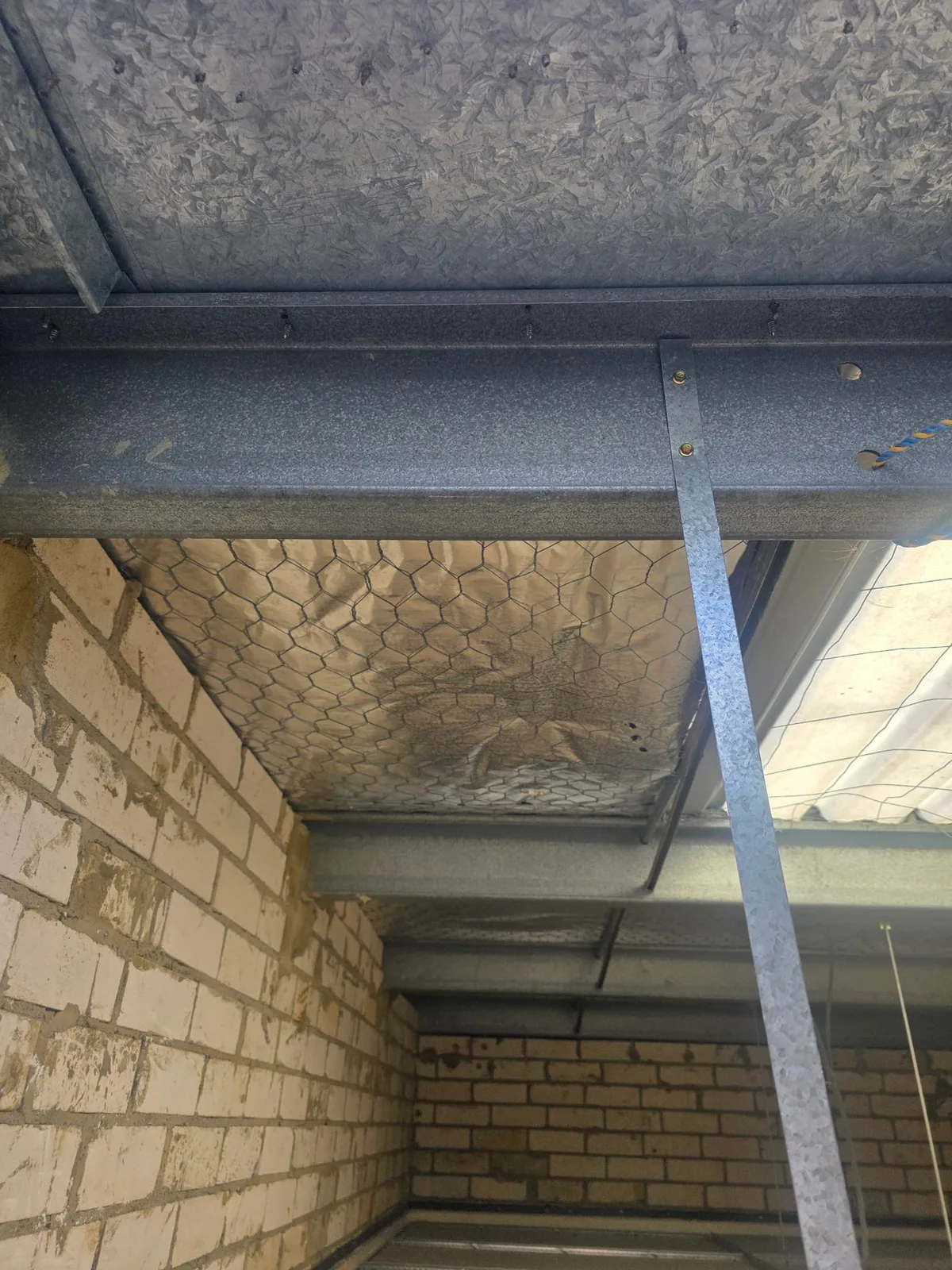 Underside inspection view with a localised dark stain below a metal roof structure